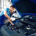worker-in-uniform-checks-engine-car-service-small